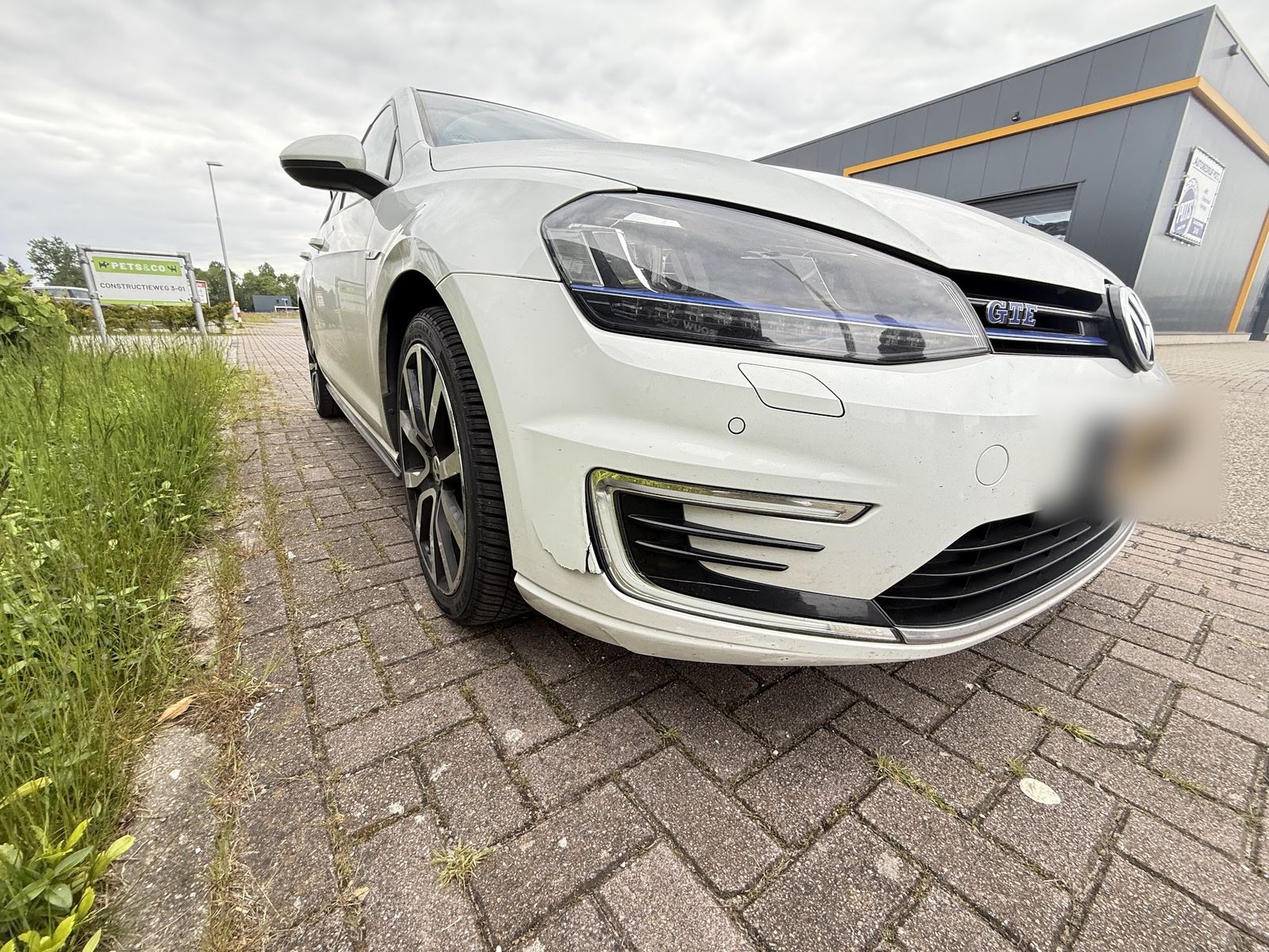 Witte Volkswagen Golf GTE voor het bedrijfspand